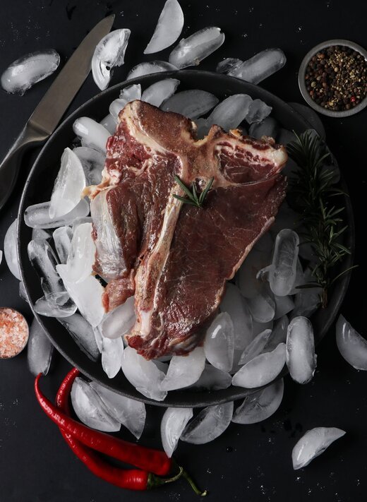 A chilled beef T-bone steak on crushed ice, ready for preparation